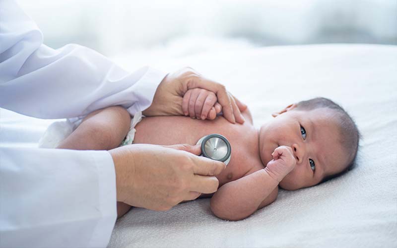 Doctor examining baby with stethoscope
